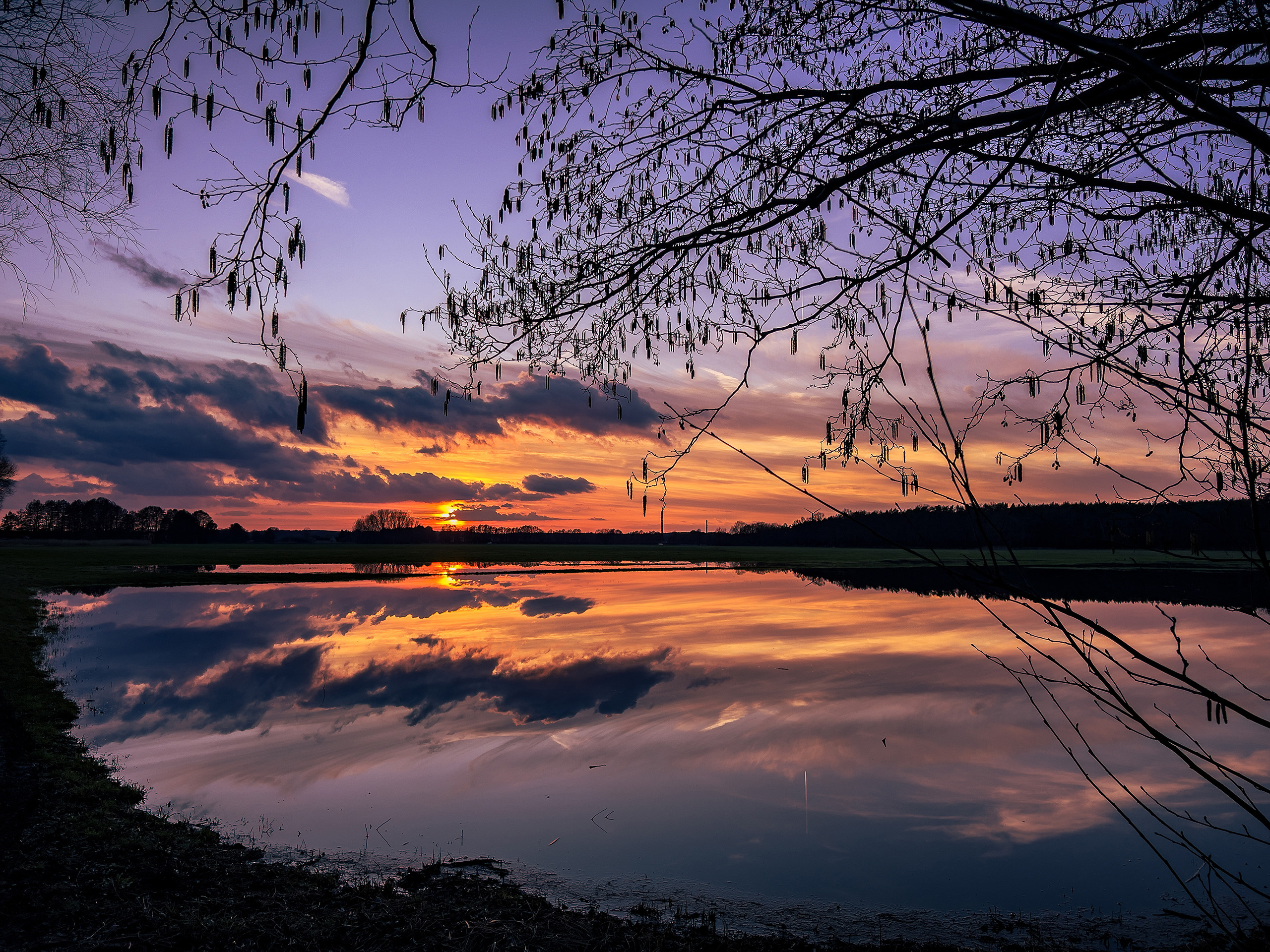 Sonnenuntergang mit Spiegelung in ueberfluteter Wiese